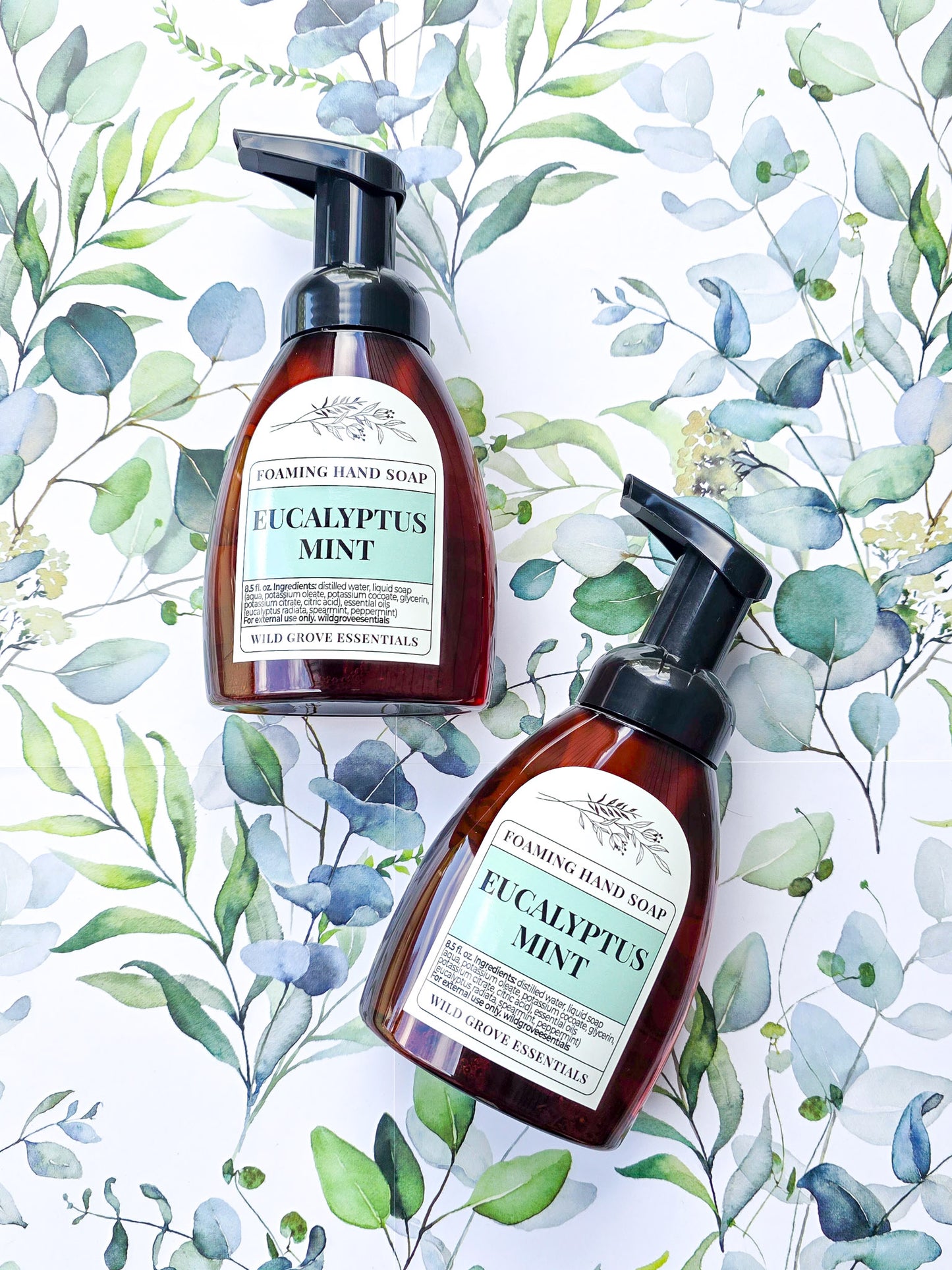 Eucalyptus mint scented foaming hand soap in amber bottles on a eucalyptus graphic background