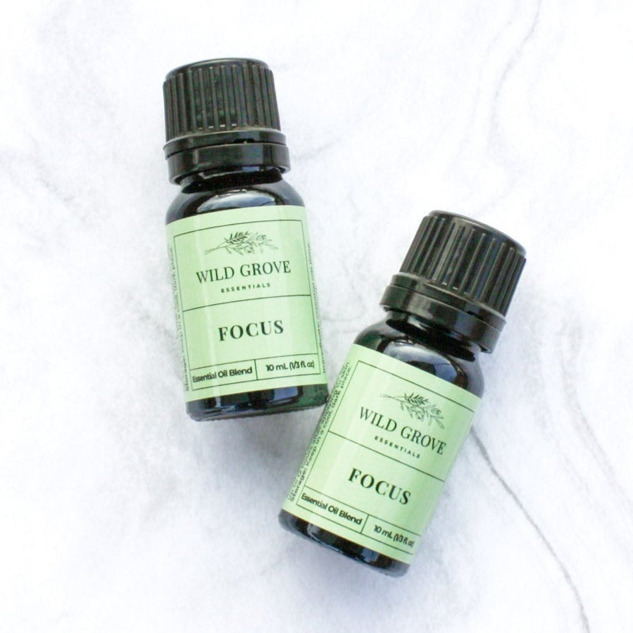 10ml essential oil amber bottles in Focus scent with a green label on a marble background.