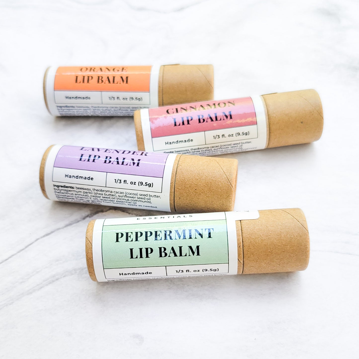 Cardboard lip balm tubes in scents of orange, cinnamon, lavender, and peppermint.