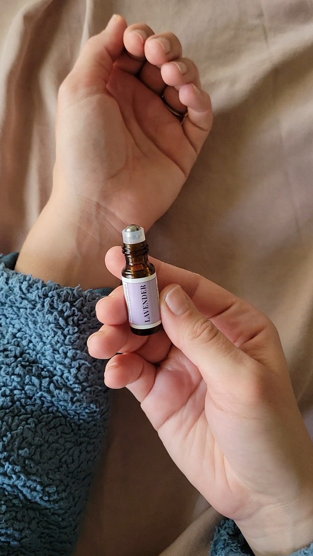Mini Lavender essential oil roll on in 5ml bottle being used to apply essential oil to wrist.
